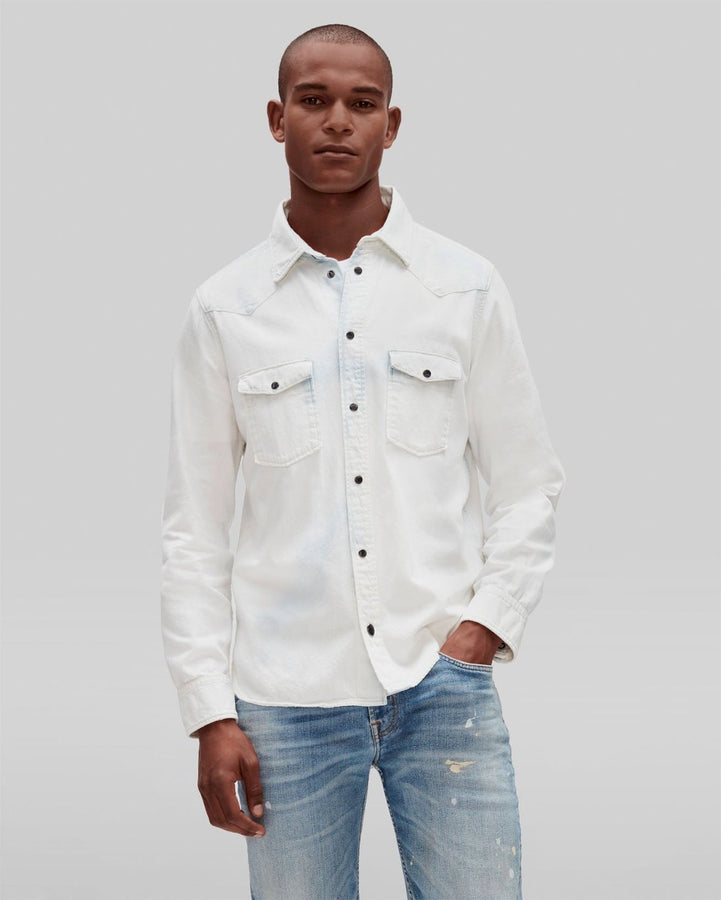 Man wearing a denim overshirt, white T-shirt and white pants with